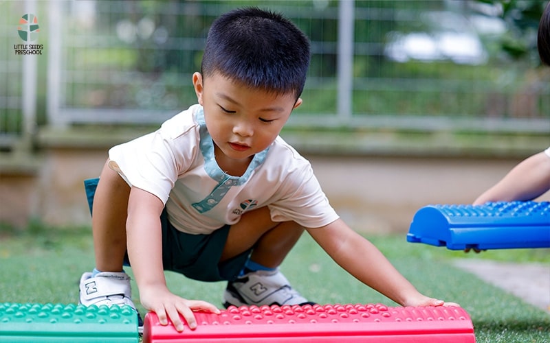 Two young boys joyfully playing with vibrant blocks on a grassy field, showcasing creativity and friendship