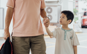 Little Seeds preschooler holding hands with an adult during arrival.