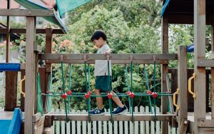 Little Seeds student practicing focus on outdoor playground bridge.