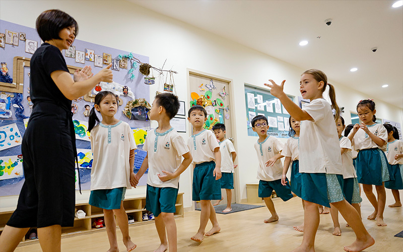 A teacher guiding a group of preschoolers through a classroom activity
