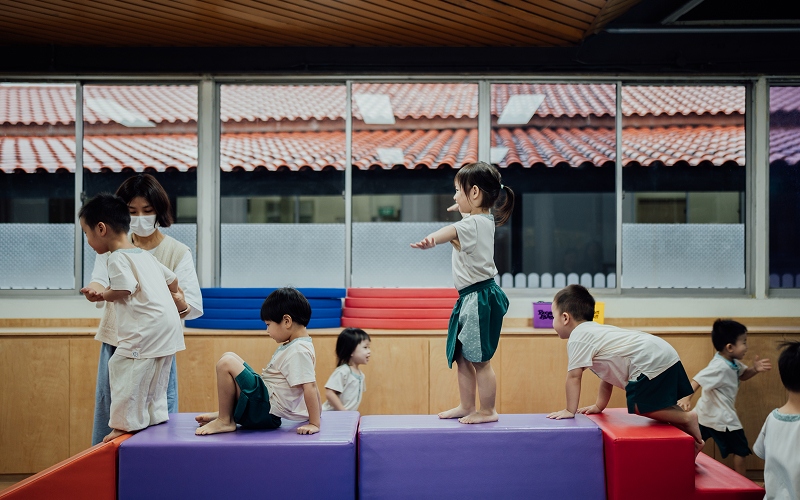 Children playing on soft play equipment in a safe environment.