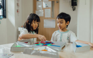 Preschoolers collaborating on a puzzle in a safe learning environment.