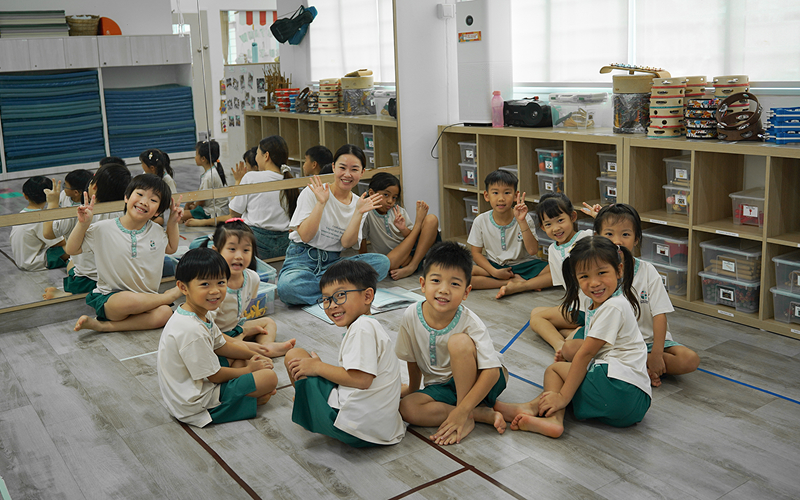 Teacher and preschool children sitting on floor during group activity.