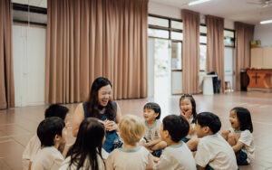 Teacher telling stories to preschool children in a circle.